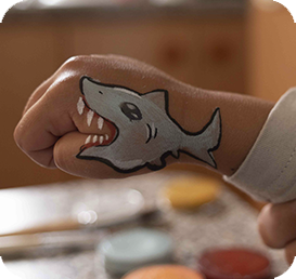 Child's hand with a painted shark